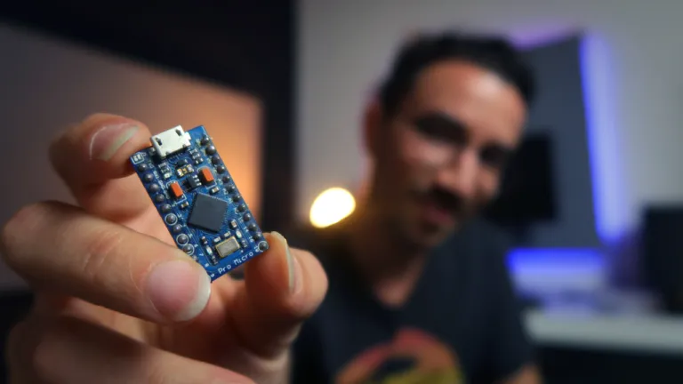 Gustavo holding an Arduino Pro Micro board